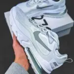 Close-up of a modern Nike sneaker being held, showcasing its sleek design and brand logo.