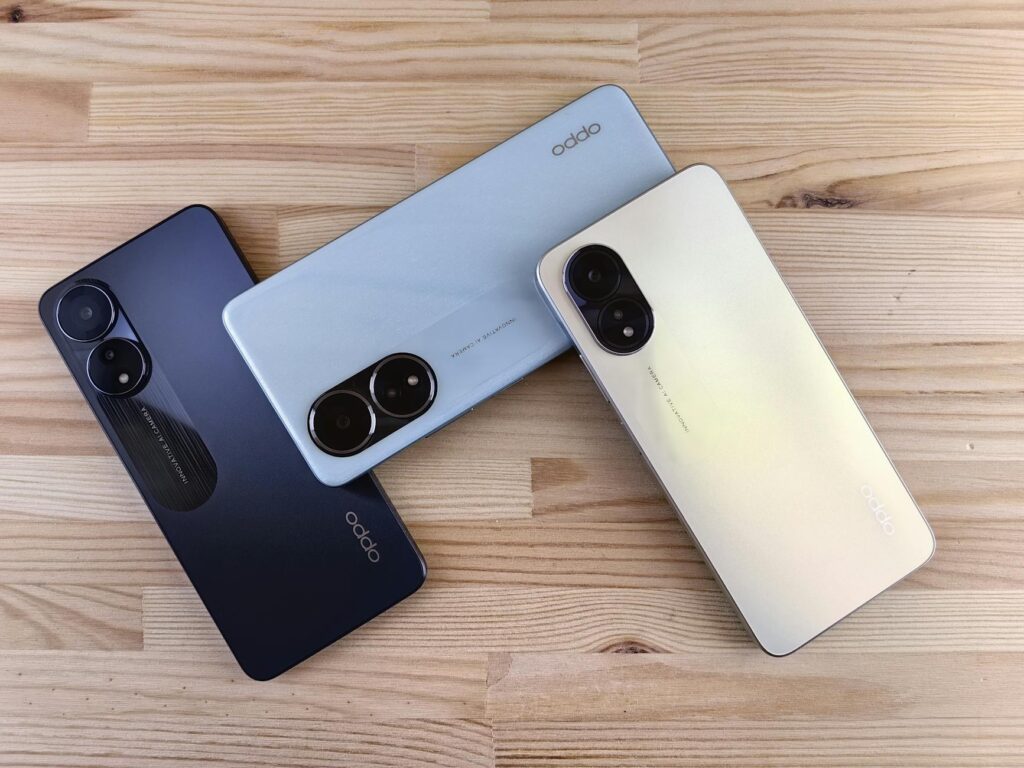 Minimalist flat lay of three smartphones on a wooden surface, showcasing sleek design and camera features.